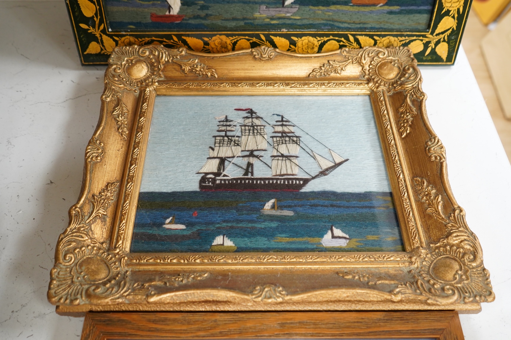 Two 20th century wool worked galleon embroideries and two similar yachting wool works, largest in decorative frame 36cm x 29cm